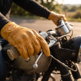 Rider wearing AtomBiker Maverick gloves gripping a motorcycle handlebar
